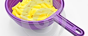 Sliced Ã¢â¬â¹Ã¢â¬â¹potatoes in purple plastic colander